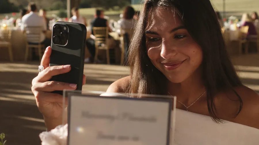 Escena ilustrativa de una invitada con su celular en una boda